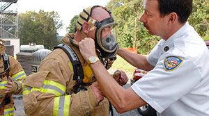 Firefighter putting on mask.