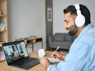 Man wearing headphones, learning online.