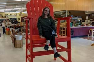 Pam E. McDonald sitting in an oversized red chair.