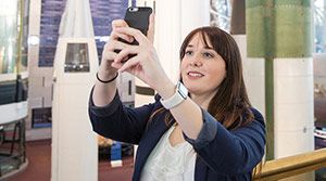 Young woman taking selphie at science center.