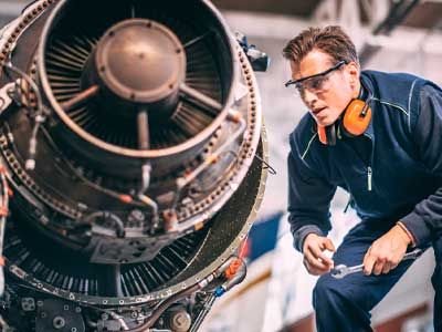 Safety worker inspecting an airplane engine.