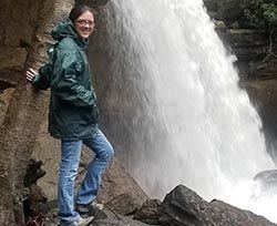 Kimberly Locy standing next to a waterfall.