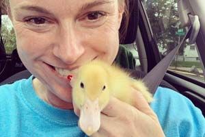 Kelly Ayers holding a small duck in a car.
