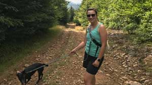 Stephanie Lusk taking her dog for a walk on a trail.