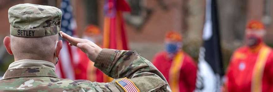 Military veteran saluting the American flag.