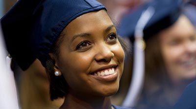 African American woman at WVU graduation smiling in her graduation cap.