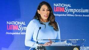 Marilyn Espinal standing at a podium and speaking at a conference.