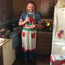 Gary Phillips wearing an apron in his kitchen.
