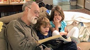 William Beasley reading with his grandkids.