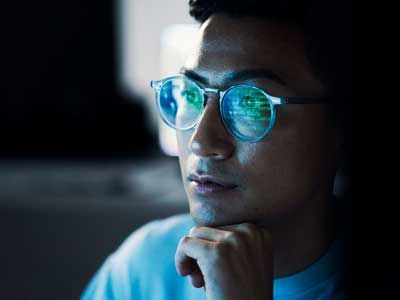 Code, Asian man and reflection in glasses, focus and programming for cyber security, hacking and modern office. Japan, male employee with eyewear and IT specialist coding, programming and thinking.